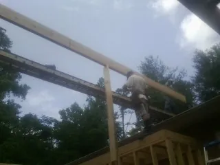 Carpenter setting a ridge beam over a new addition frame — Ice Dam Removal by Roofing Brothers in Whitehouse Station