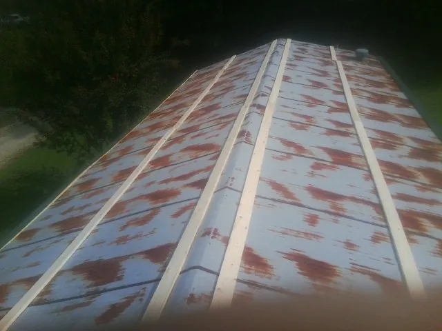 Rusted metal roof panels with new wood purlins before replacement — Storm Damage Roof Repair in Whitehouse Station by Roofing Brothers