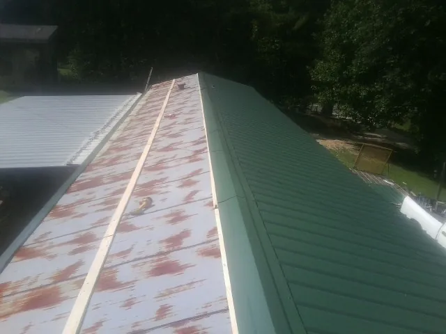 Old rusted panels beside newly installed green metal roofing — Wind Damage Roof Repair by Roofing Brothers in Whitehouse Station