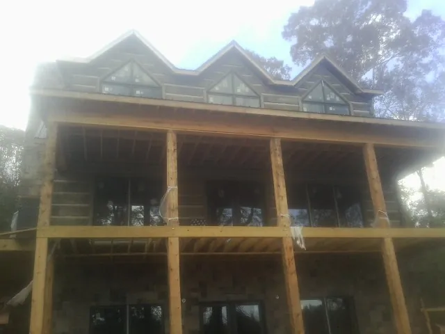 Dormers and porch framing on a large log home under construction — Roof Coating work by our crew in Whitehouse Station