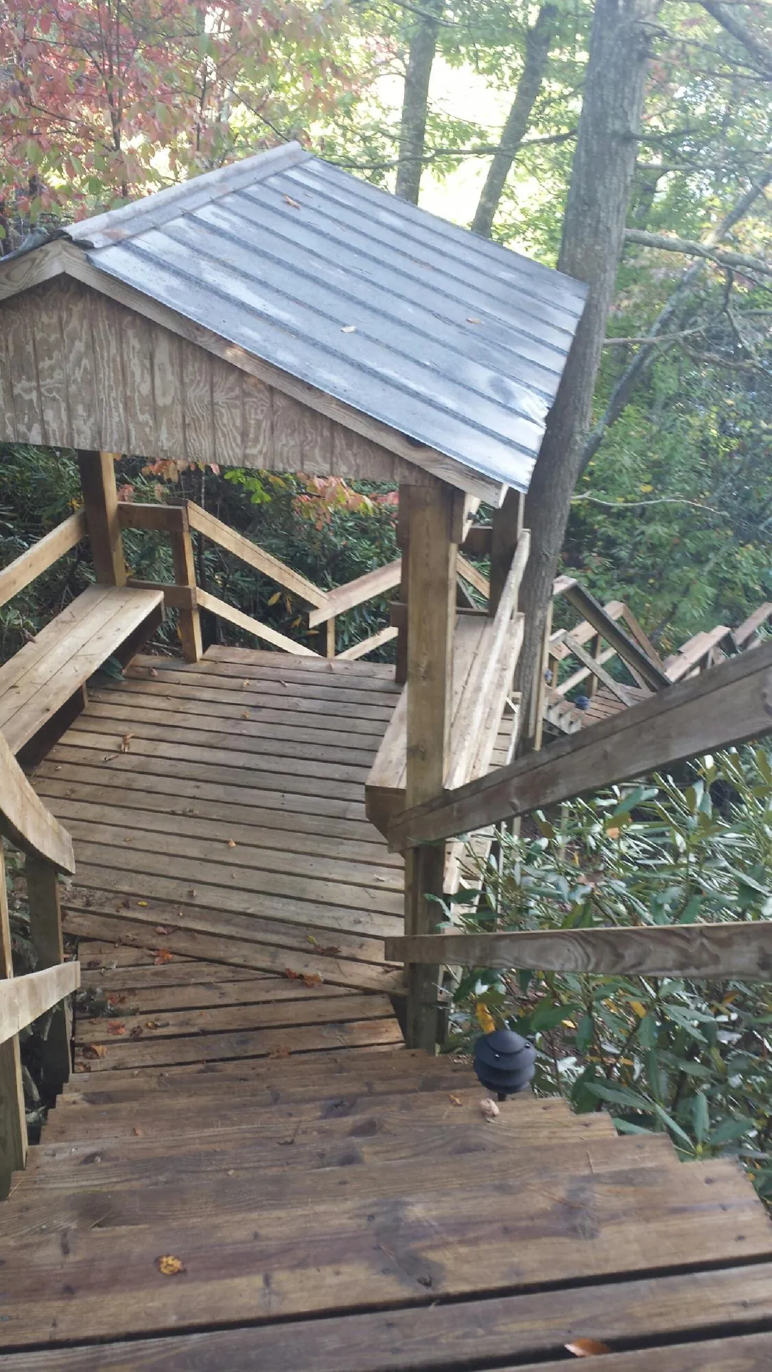 Metal roofed shelter over wooden steps on a wooded walkway — Skylight Repair & Installation work by our crew in Whitehouse Station
